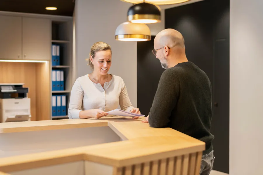 Ärztin berät Patient an Theke