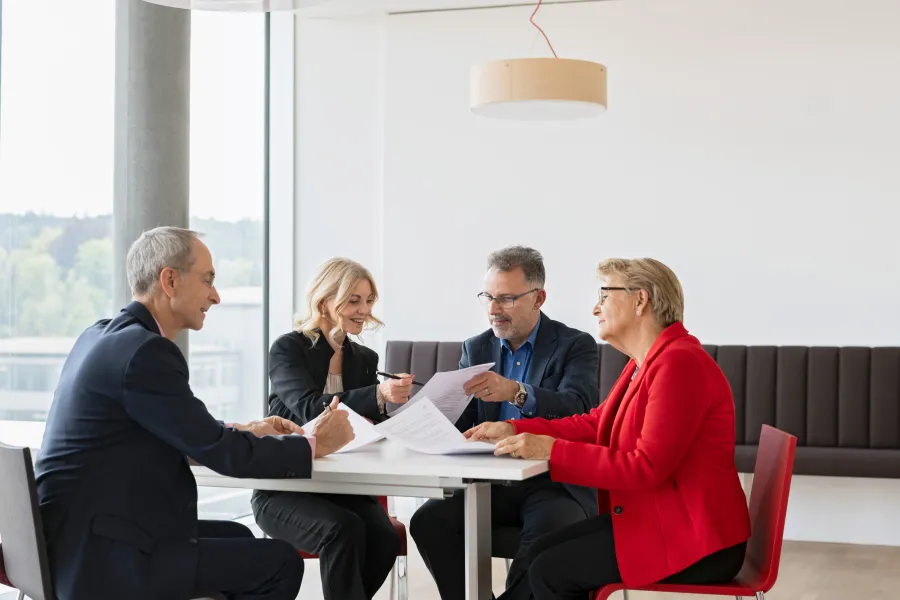 Mitarbeitende sitzen am Tisch