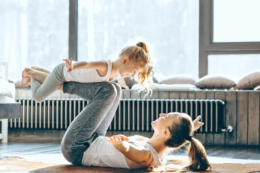 Mutter macht mit kleiner Tochter Yoga