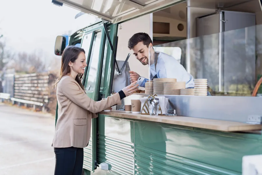 Eine Frau beim Bezahlen an einem Foodtruck