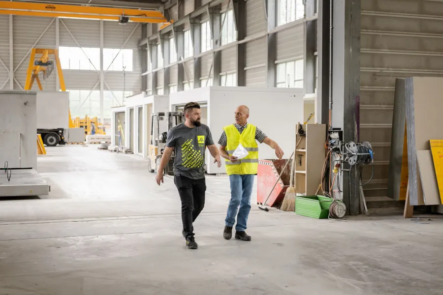 Zwei Mitarbeitende in de Fabrikhalle