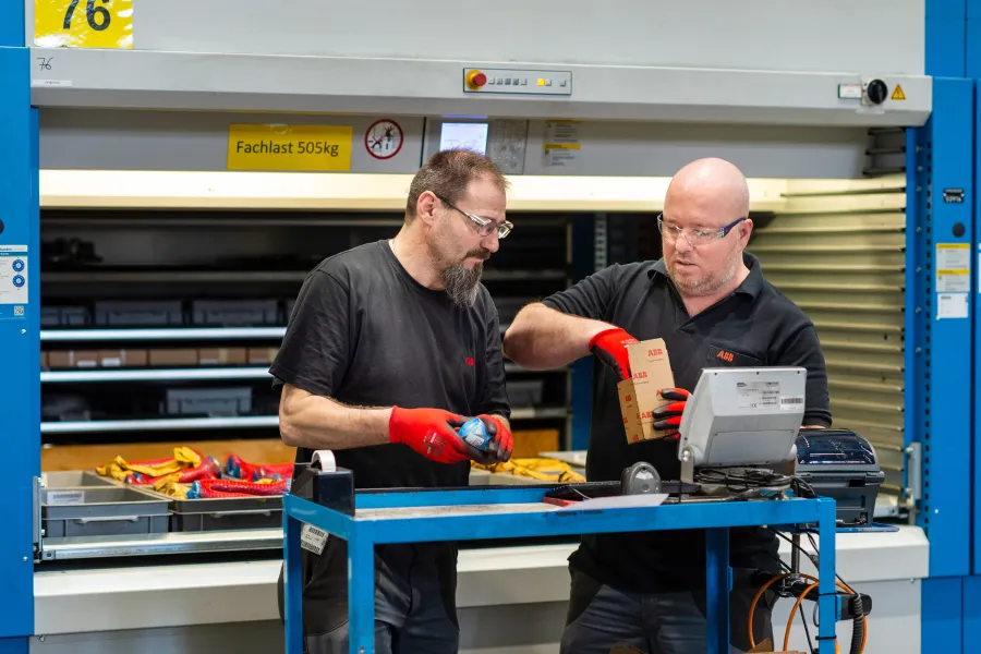 Zwei Männer bedienen in der Werkstatt eine Maschine