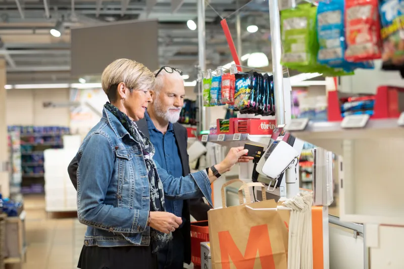 Rentnerpaar beim kontaktlosen Zahlen an Kasse