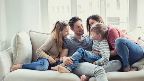 Familie sitzt auf Sofa