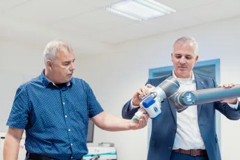 Mitarbeiter und Chef bedienen Roboter